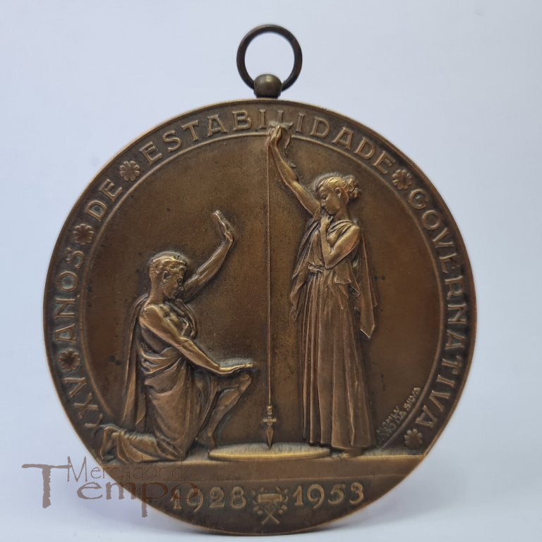 Medalhão em bronze comemorativo dos XXV anos de estabilidade Governativa, 1928 – 1953, com a presença das bandeiras de todo o mundo Português. Assinada : João da Silva. 