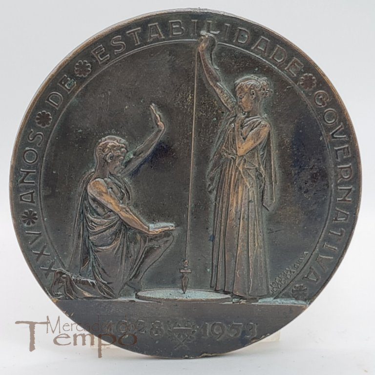 Medalha em bronze comemorativa dos XXV anos de Estabilidade Governativa, com a presença das Bandeiras de todo o Mundo Português. Datada de 1953, assinada : João da Silva